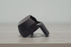 Spray Doctor in black on a wooden surface, side view