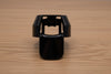 Black ergonomic spray can adapter, Spray Doctor, on a wooden surface - front perspective view.