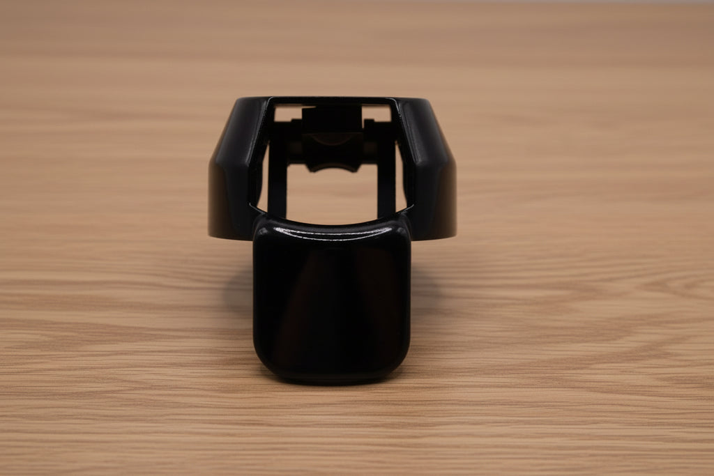 Black ergonomic spray can adapter, Spray Doctor, on a wooden surface - front perspective view.