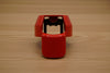 Red ergonomic spray can adapter, Spray Doctor, on a wooden surface - front perspective view.