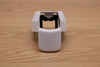 White ergonomic spray can adapter, Spray Doctor, on a wooden surface - front perspective view.